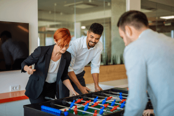 Office colleagues playing foosball